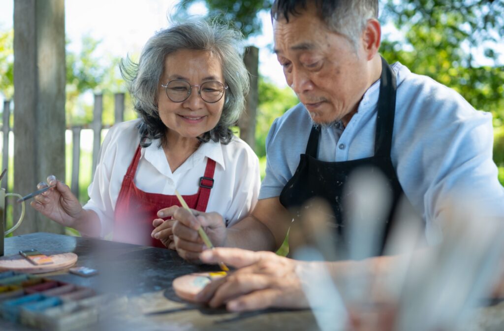 An older adult couple enjoying painting together.