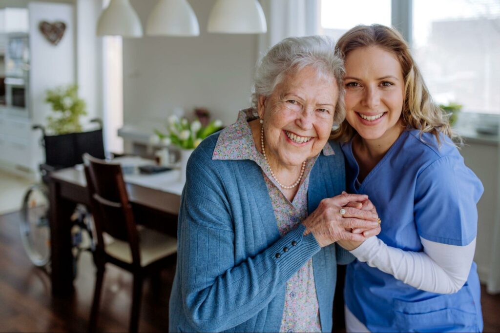 a caregiver holding and smiling a senior
